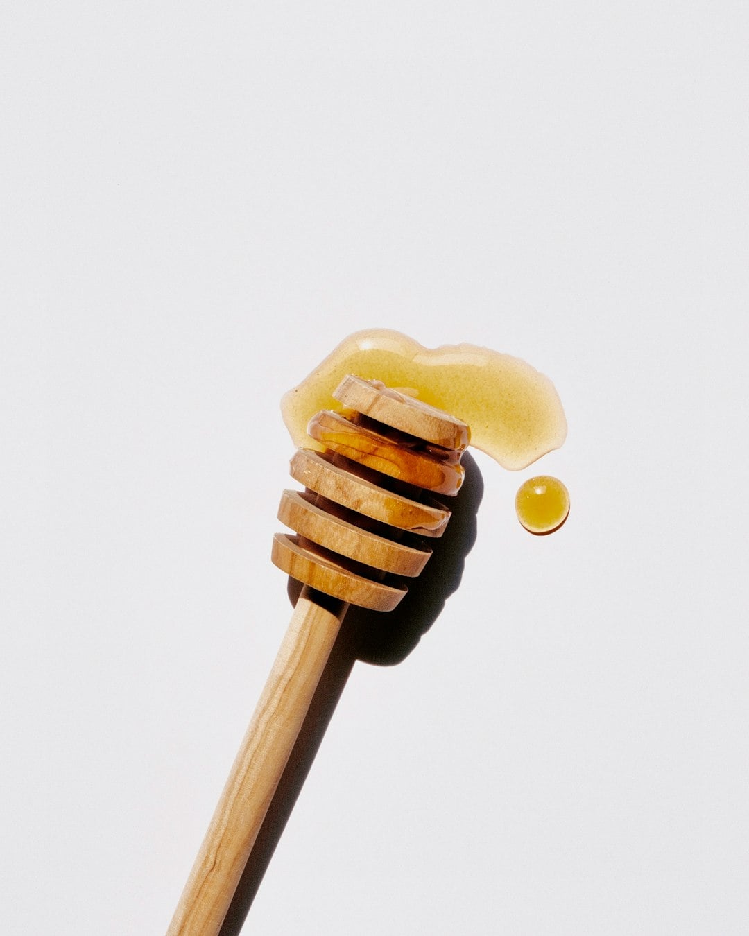 Honey jar with wooden dipper, photo by Jocelyn Morales on Unsplash